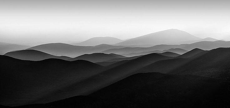 Layered ridgelines fading into mist, in black and white